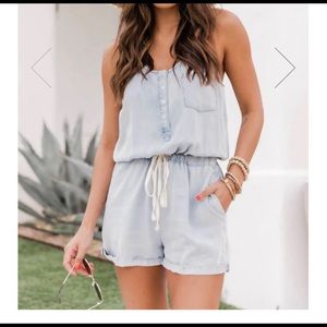 Pink Lily walking away blue chambray romper.